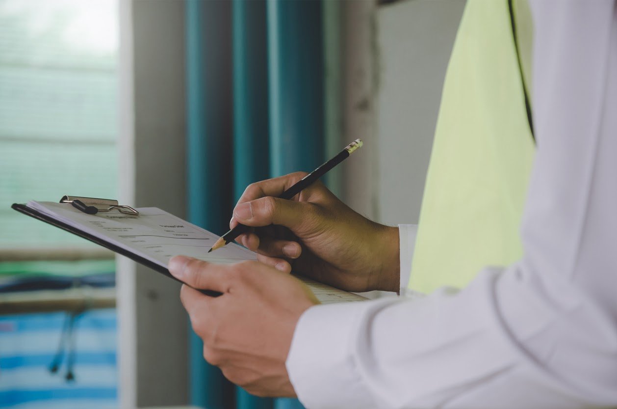 Person doing move-out inspection on clipboard.