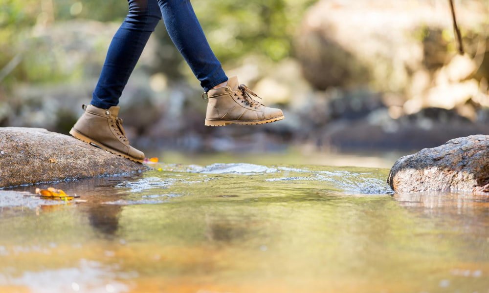 person hiking across river