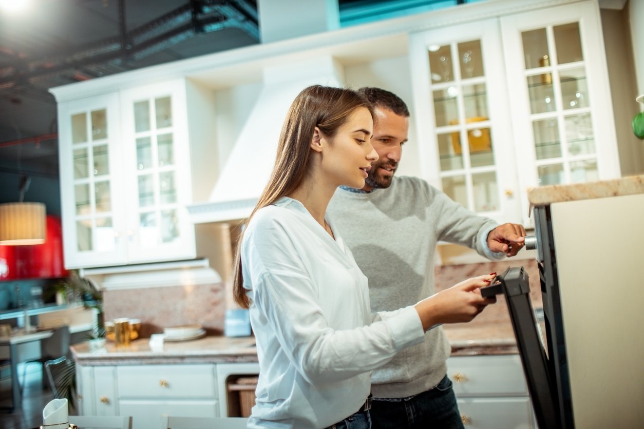 young couple looking at new appliances for rental property