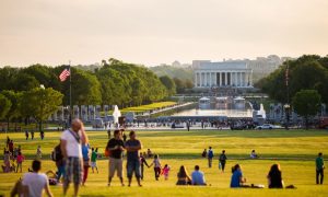 Tourists enjoy the lawn during a sunny day in front of the Lincoln Memorial on the National Mall.