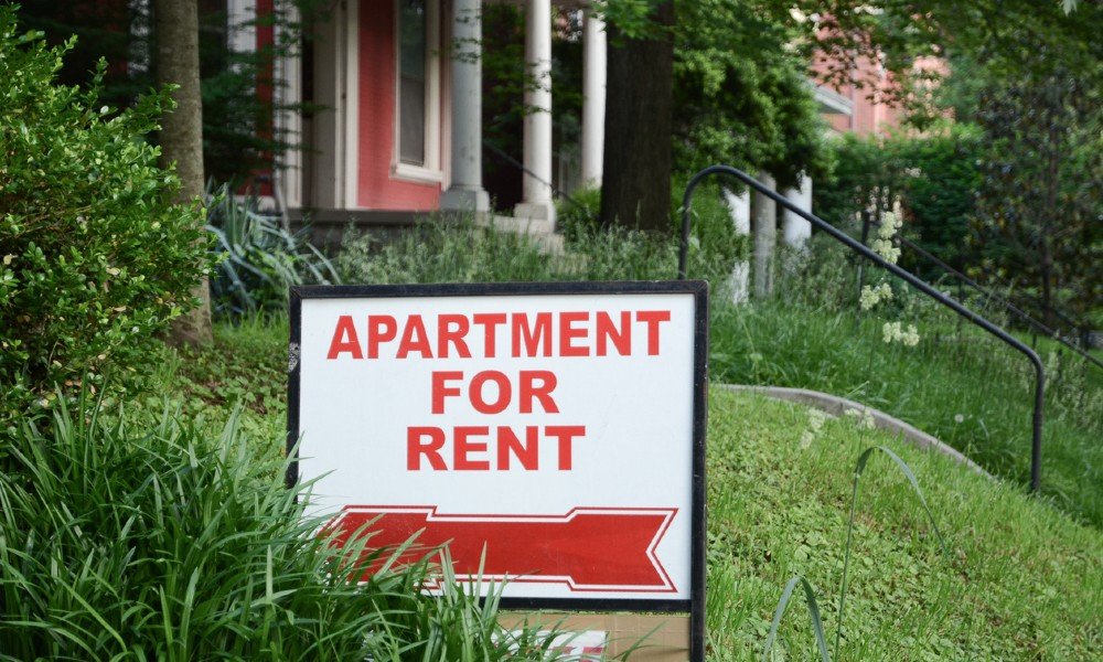 Apartment for rent sign in the front yard of a residential building, illustrating the occasional need for landlord rental concessions.