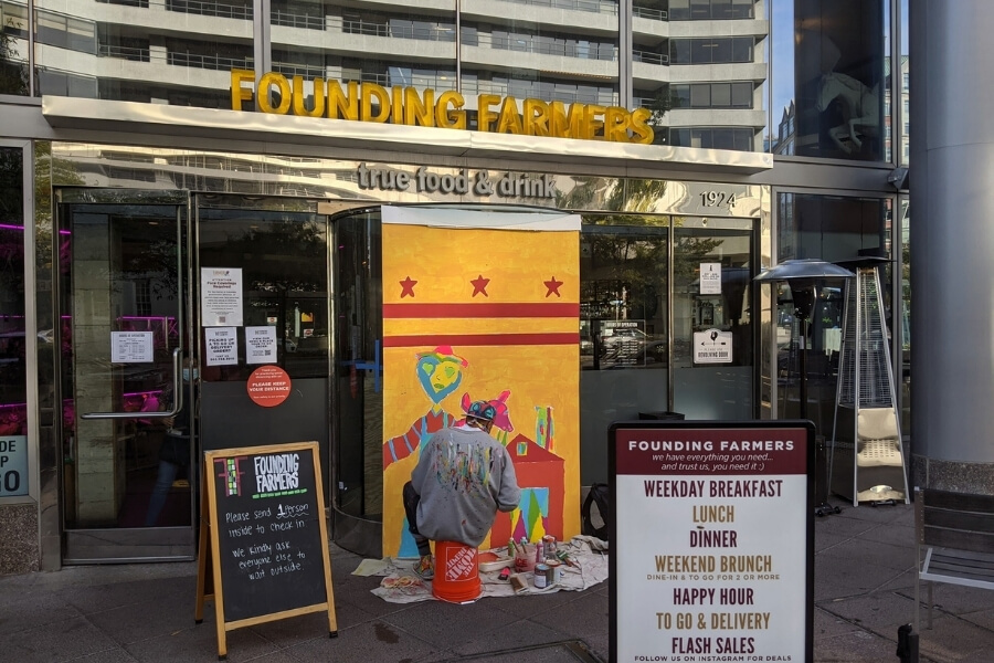 8 Spots to Try for Brunch in Potomac, Maryland 2 Outside of MoCo's Founding Farmers with someone painting a mural in front of the entrance