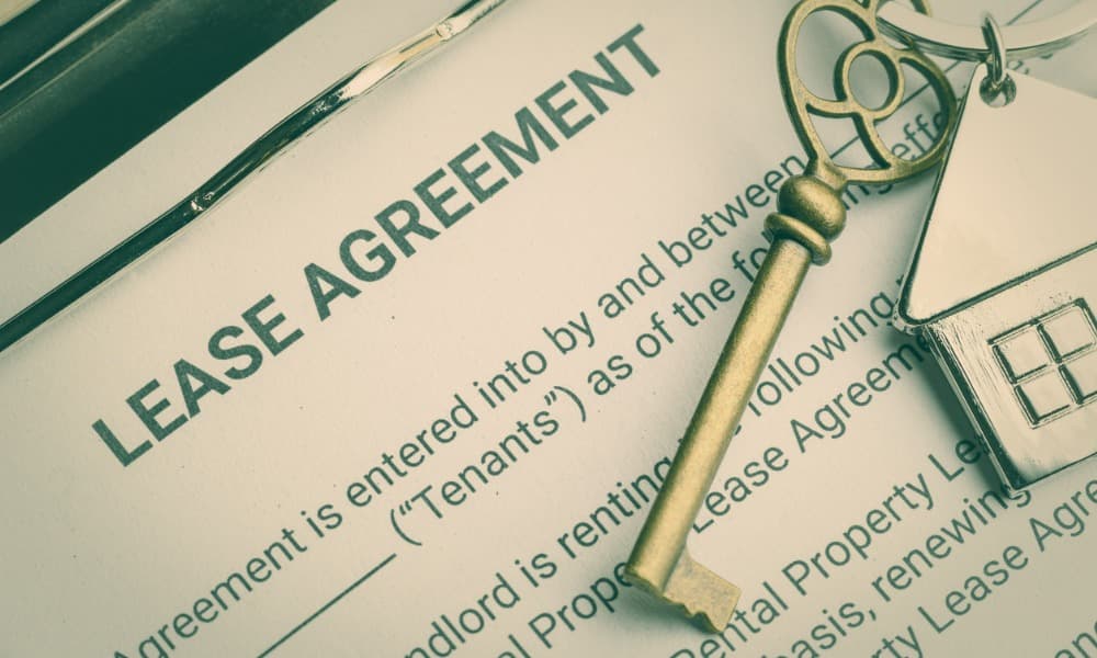 A lease agreement and a key to a new home, possibly enclosed with a new landlord letter.