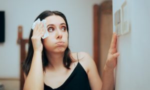 A tenant adjusting the thermostat after learning the apartment air conditioning laws in D.C.