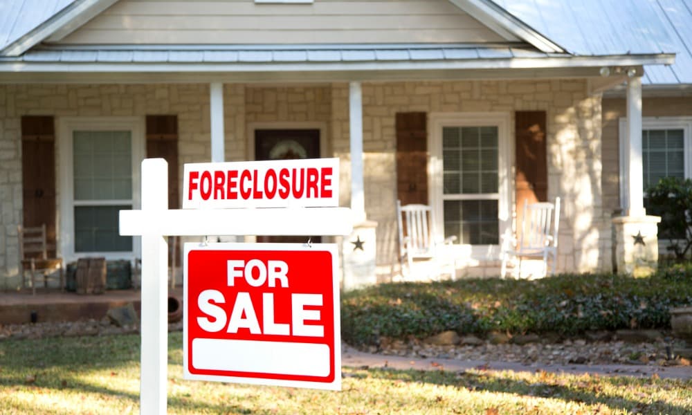 Investing in foreclosures, like this house with a foreclosure sign out front, can help you get started in the D.C. real estate market