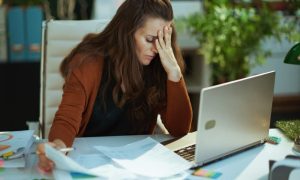 A worried landlord in front of a laptop in need of stress free property management