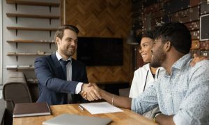 A landlord finalizing an agreement with some tenants after learning how to negotiate rent