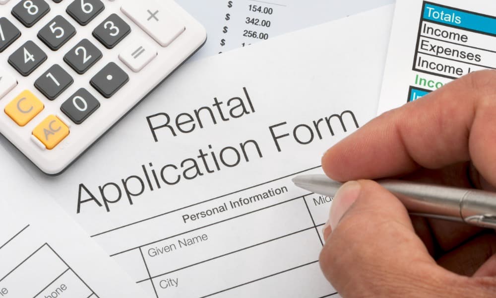 A man filling out a form after learning the valid reasons to deny a rental application