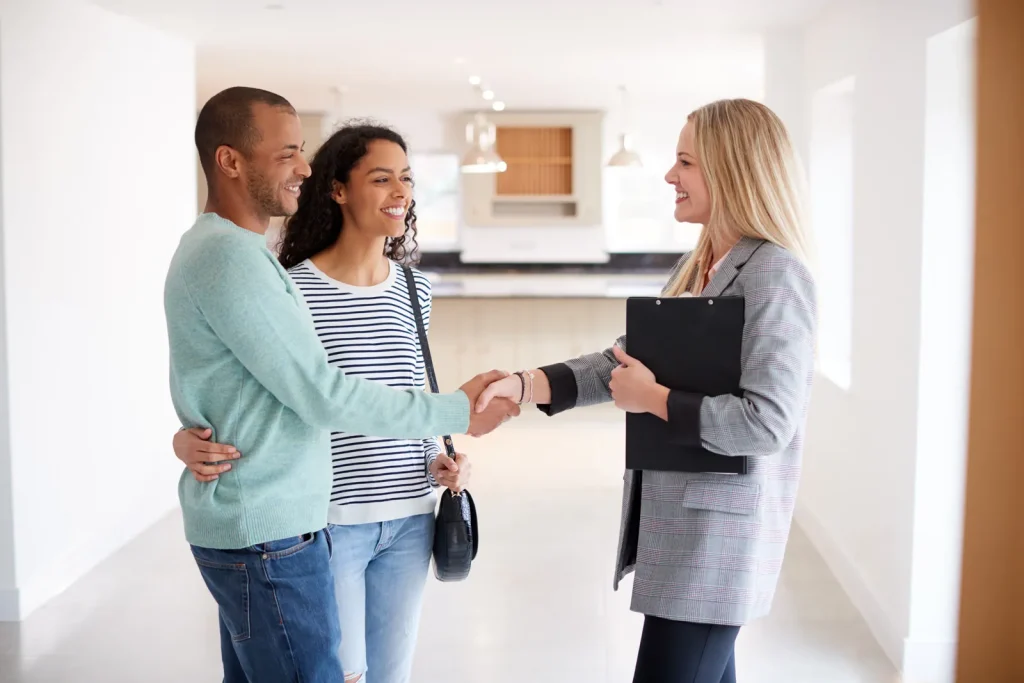 Client Resources 2 Nomadic real estate agent shaking hands with prospective homebuyers.