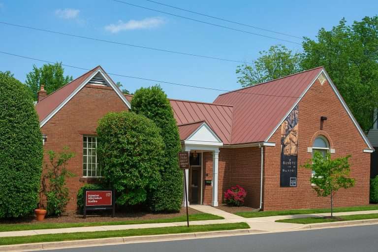 Alexandria Black History Museum - single-story red brick building with copper roof, white columns, and historical mural depicting African American figures on exterior wall