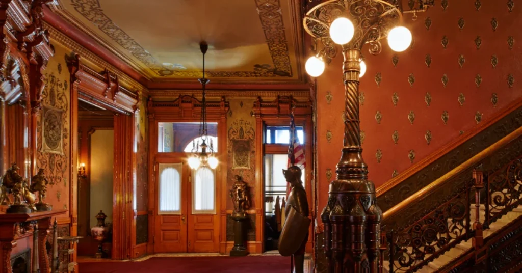 Ornate Victorian-style interior of the Heurich House Museum in Washington, DC, featuring intricate woodwork, decorative lighting, and historic furnishings.