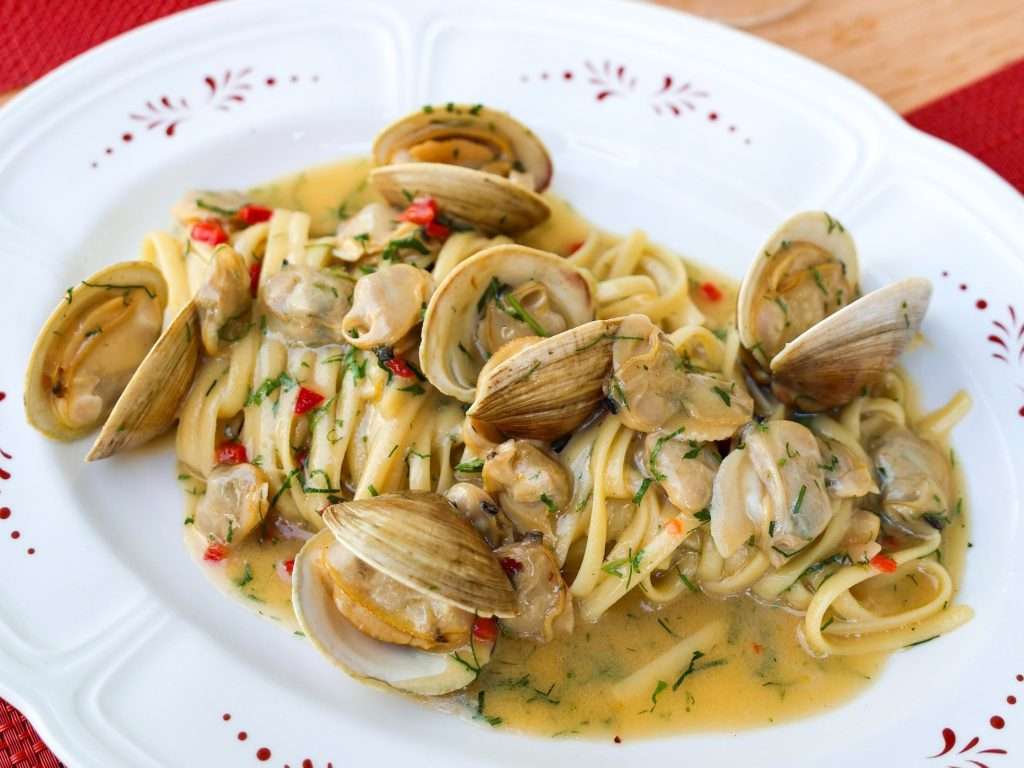 Fresh linguine with clams in a white wine garlic sauce, garnished with herbs and red chili, served at Sfoglina Italian restaurant in Washington, DC.