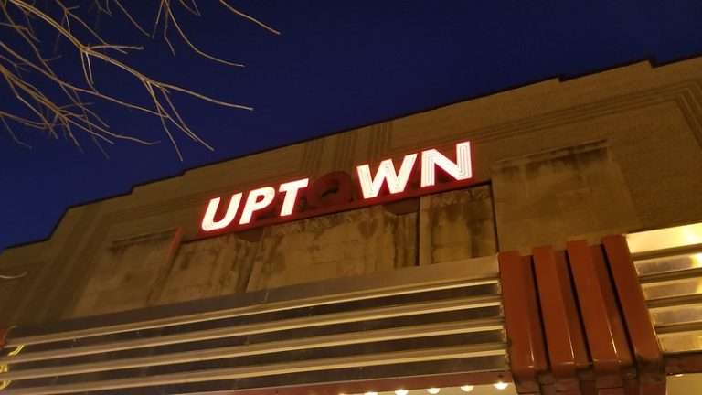 Night view of the historic Uptown Theater marquee in Washington, DC, with illuminated red and white signage against a deep blue sky.