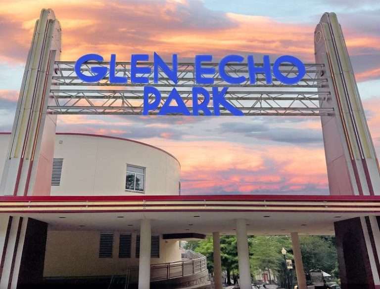 Art Deco entrance of Glen Echo Park with bold blue letters against a vibrant sunset sky.