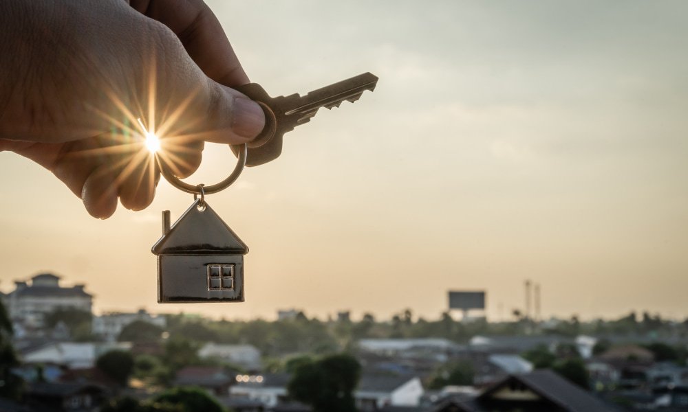 A person holding keys after buying a rental property