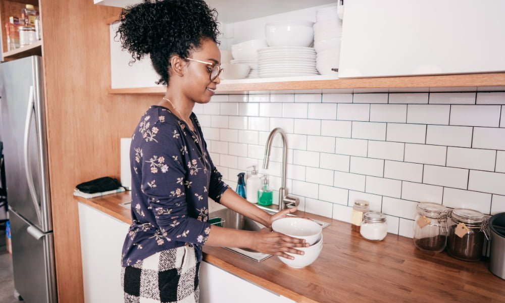 Woman cleaning dishes in her apartment