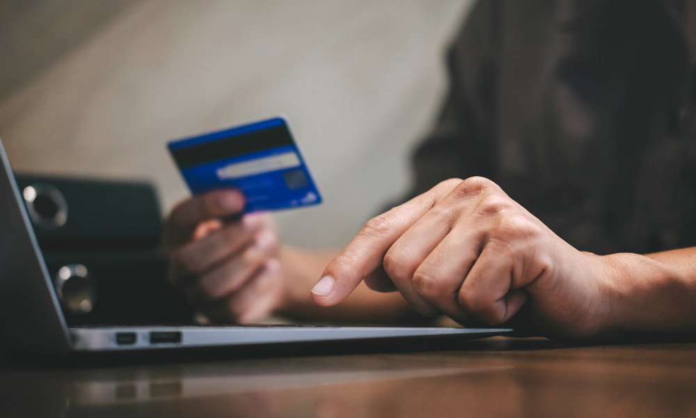 person typing card info into computer