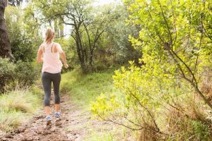Blonde athlete jogging on trail in the nature