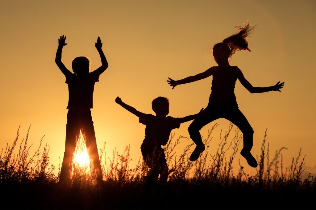 Three kids plating in a sunset