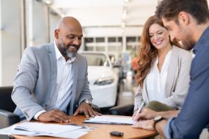 Man signing contract to buy new car