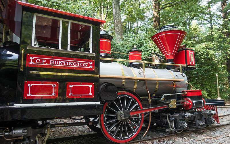 Vintage steam locomotive with red and black accents labeled "C.P.