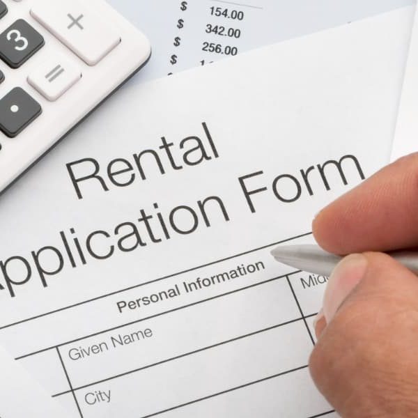 A man filling out a form after learning the valid reasons to deny a rental application